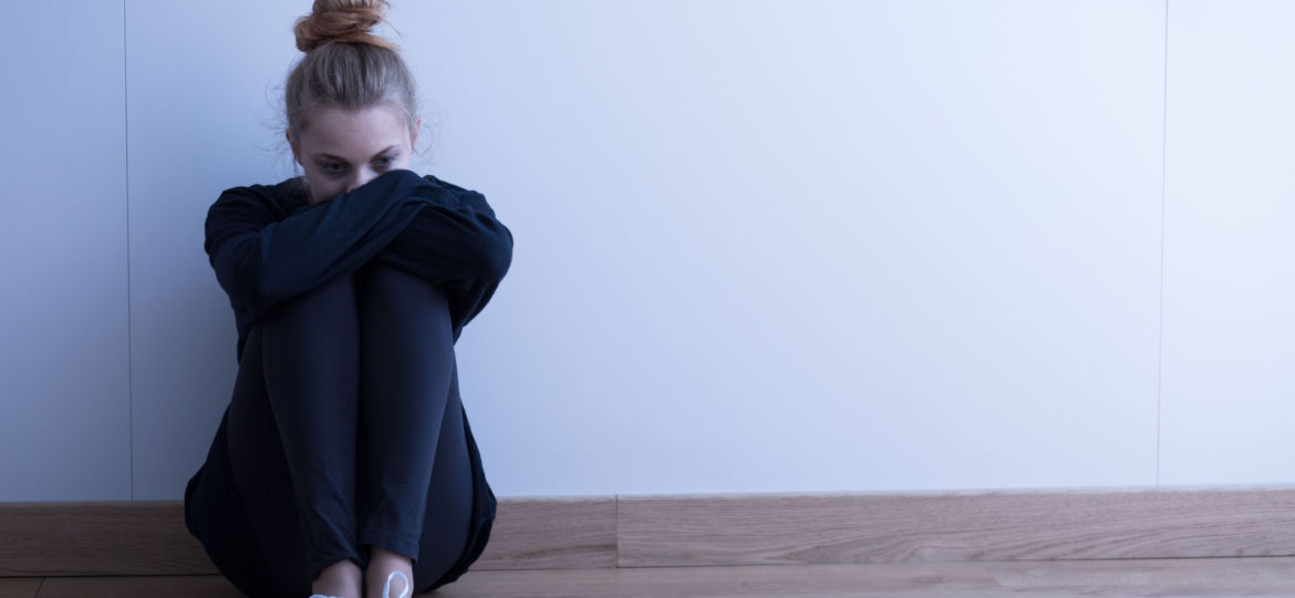 woman sitting on floor depressed