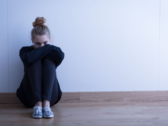 woman sitting on floor depressed